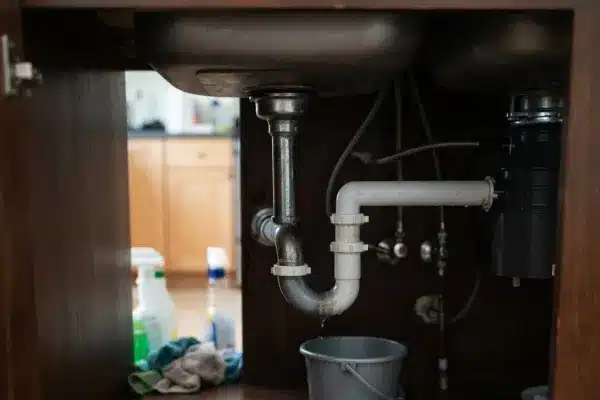 Wrench pliers and plumber tape arranged for sink pipe repair